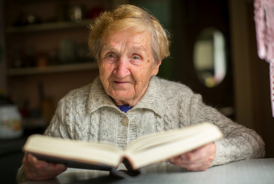 Personne âgée tenant son livre de mémoires entre ses mains