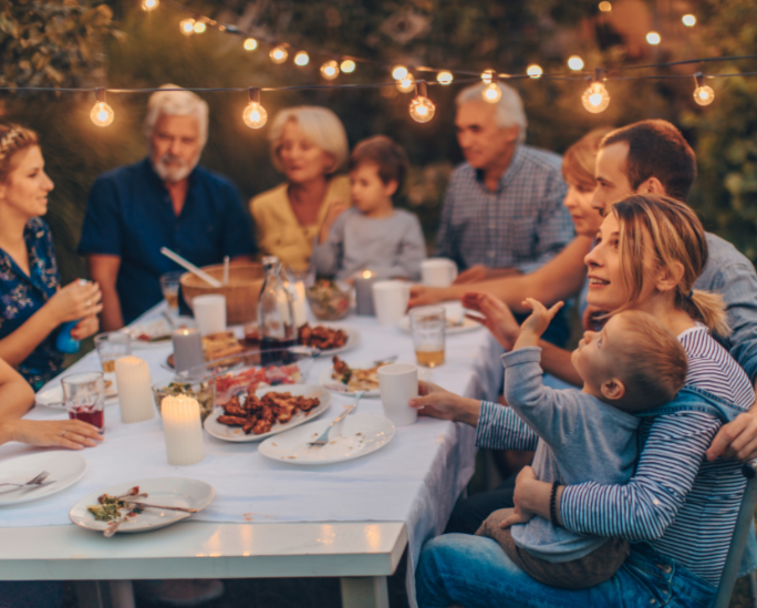Illustration d'un moment en famille Un repas en famille, un soir d'été, en extérieur, sous une guirlande lumineuse;. Une histoire à raconter et à partager